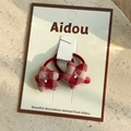 Detalle de gomas de pelo de estrella a cuadros rojos con perlas en tarjeta - Goma de Cuadros