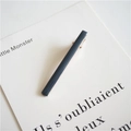 Close-up of minimalist dark blue-grey glazed hair clip on a white display card - Sea Green