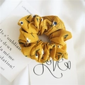 Close-up of yellow floral chiffon scrunchie with white daisies and textured pleats - Floral Yellow