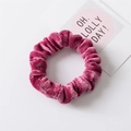 Dettaglio dell'elastico per capelli in velluto rosa con texture morbida - Rosso rosa