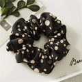 Close-up of black scrunchie with beige polka dots on a minimalist white tray - Multicolor Dot Black