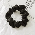 Close-up of black satin hair scrunchie with soft silk texture and elegant fabric folds - Black
