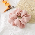 Detail view of pink cotton linen scrunchie with natural fiber texture on a woven mat - Pink