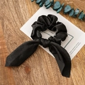 Elegant black satin hair scrunchie with bunny ear bow on a rustic wooden background - Black