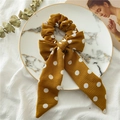 Detail view of ginger yellow polka dot bow scrunchie on a decorative marble tray - Coffee Polka Dot