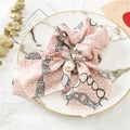 Vue détaillée du chouchou en satin rose à pois blancs et élégante perle en pendentif - Chaîne Rose