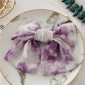 Primer plano de un lazo para el pelo tie-dye morado en un plato de mármol con eucalipto - Tie-Dye Púrpura