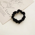 Elegant black satin scrunchie with pleated texture on decorative card backdrop - 6cm Satin Black