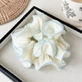 Creamy white pleated scrunchie with blue piped edges on a soft fabric tray - Pleated Contrast Scrunchie / Light Blue