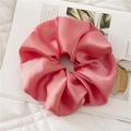 Detail view of pink satin scrunchie showing glossy fabric texture and soft pleats - Pink