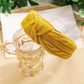 Close-up of bright yellow cable knit headband with a stylish knotted detail - Knitted Yellow