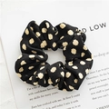 Black polka dot fabric scrunchie with soft knit texture on a white decorative card - Spotted Black