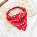 Détail d'un bandeau triangle rouge à pois avec bande élastique sur un fond en dentelle - Bandana Rouge à Pois