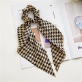 Detail of satin houndstooth scrunchie with long ribbons on an open fashion magazine - Coffee Houndstooth