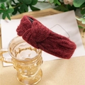 Serre-tête en tricot bordeaux avec nœud central posé sur un verre décoratif - Rouge Vin Tricoté