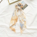 Dettaglio dell'elastico per capelli tie-dye zenzero con nastri lunghi su lino bianco - Nastro Marrone Tie-dye