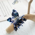 Macro d'une pince à cheveux papillon en acétate avec motif marbré bleu sur bois - Marbre Bleu