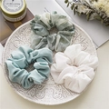 Drei Haargummis aus Chiffon mit Blumenmuster auf einem weißen Keramikteller im Detail - Blau & Weiß Set