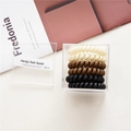 Dettaglio di sei elastici a spirale ad alta elasticità in scatola trasparente in colori neutri - Beige Cachi Nero