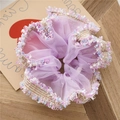 Nahaufnahme von lila Mesh-Haargummi mit Blumen-Spitzenkante und Goldfaden-Details - Gewebtes Violett
