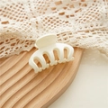 Detail of cream white hair claw clip with interlocking teeth on vintage lace background - White