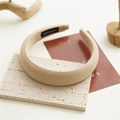 Dettaglio del cerchietto imbottito beige con etichetta fatta a mano su base di pietra - Color Tè al Latte