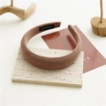 Dettaglio del cerchietto in spugna marrone con tessuto twill ed etichetta artigianale - Cachi