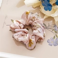Detailansicht eines rosa Satin-Haargummis mit Blumenmuster auf Vintage-Hintergrund - Satin Blumen Rosa