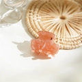 Detailopname van een kleine acetaat haarklem met marmerpatroon op een warme achtergrond - Kleine Klem Oranje Roze Marmerpatroon / Dieproze