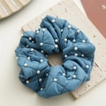 Detalle del coletero acolchado azul con perlas blancas y patrón de costura de rombos - Azul
