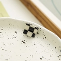 Close-up of square black and white checkerboard hair claw clip on ceramic plate - Square