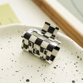 Detail view of square black and white checkerboard hair claw clip on ceramic tray - Small Cube