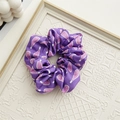 Detailed close-up of periwinkle blue satin scrunchie with pink floral patterns - Drifting Bottle