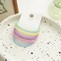 Detalle de cinco gomas de pelo en espiral de colores pastel presentadas en una tarjeta blanca - Espiral Fina Multicolor
