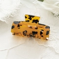 Macro detail of tortoiseshell leopard print hair claw clip made of polished acetate - Hollow Dark Coffee