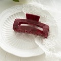 Detail of dark red marble acrylic claw clip on a white lace and ceramic tray - Hollow Dark Red