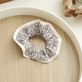 Detailansicht eines floralen Scrunchies in Beige mit zarten lila Blumenmustern - Wisterie Lila