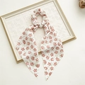 Détail d'un chouchou floral beige avec longs rubans sur cadre blanc vintage - Rose Floral