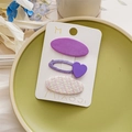 Three cute purple and beige hair clips on a ceramic plate with floral background details - Purple Heart Set