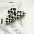 Detail of elegant checkered acetate hair claw clip with vintage gold chain and jewel patterns - Checkered