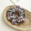 Detailed view of a red and black plaid scrunchie displayed in a woven basket - Black and White Plaid
