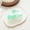 Detail of transparent acrylic claw clip featuring fresh lime slice patterns on stone tray - Semicircle Lemon