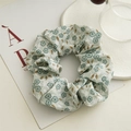 Detailansicht eines geblümten Scrunchie mit blauen Blumen auf hellgrünem Stoff - Grün Blumen