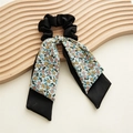 Détail d'un chouchou à fleurs avec longs rubans posé sur un plateau décoratif en bois - Bleu Ruban Double Couche