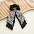 Détail d'un chouchou à motif floral avec de longs rubans sur un support en bois - Violet Ruban Double Couche