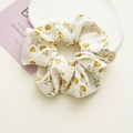 Detailed close-up of cream floral scrunchie with yellow flowers on a white plate - Small Yellow Flower