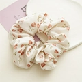 Detailed shot of cream floral scrunchie with red tulip pattern on a decorative tray - Little Red Flower