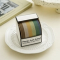 Detail of colorful woven elastic hair bands on a white porcelain plate with retro books - Spiral Mixed Colors
