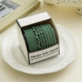 Detail of dark green elastic hair bands set with woven textures in a square box - Green