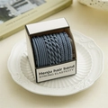 Detailed view of elastic blue hair bands with diverse textures in an elegant ceramic dish - Blue